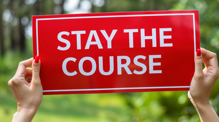 Motivational concept  woman holding sign  stay the course  with abstract background.の素材