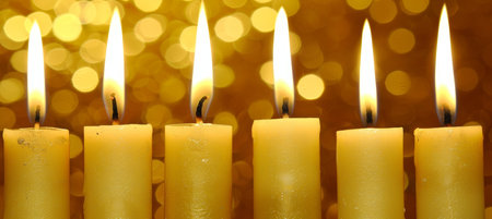 Passover candle lighting   close up of flickering flames with warm glow and space for text.の素材