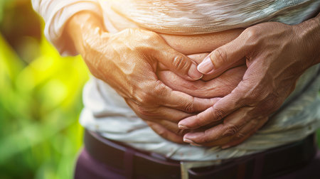 Man experiencing abdominal pain after exercise in the park   muscle injury unwellness conceptの素材