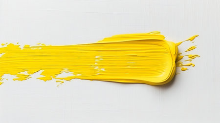 Vibrant yellow paint stroke on white background, perfect for design projects and creative conceptsの素材