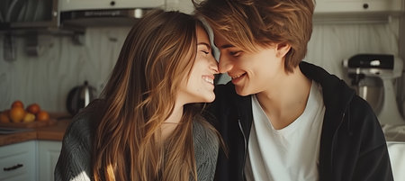 Joyful lesbian couple embracing in bright white kitchen, sharing love and happiness at homeの素材