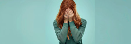 Woman in distress covering her face with hands, isolated on pastel background with space for text.の素材