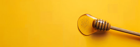 Artisanal honey dripping from dipper onto glistening comb, golden sweetness, banner copy spaceの素材