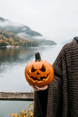 Sinister vampire in fog with grinning pumpkin  eerie atmosphere with vibrant contrastの素材