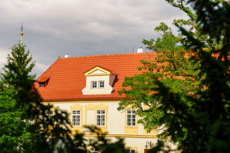 Charming European-style Two-Story House Featuring Red Tile Roof and Elegant White Wallsの写真素材