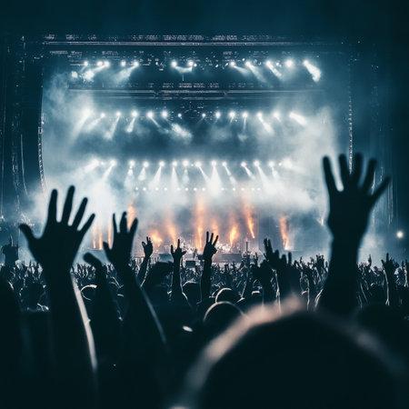 Crowd with raised hands at concert enjoying a rock music show, vibrant stage lights performanceの素材