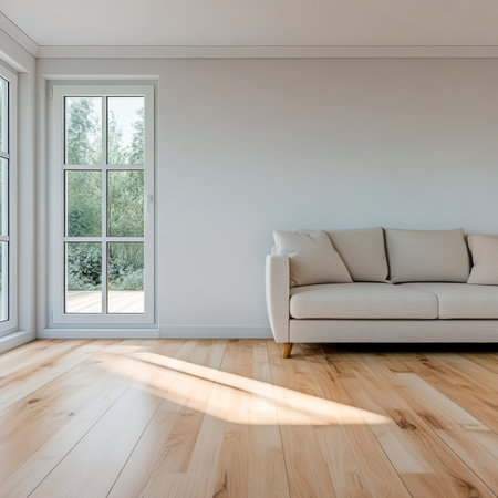 Bright, airy living room interior with a comfortable sofa, large windows, and hardwood flooring.の素材