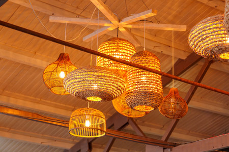 Elegant and Rustic Hanging Wicker Lanterns with Glowing Lights for Cozy Ambiance in Home Decorの写真素材