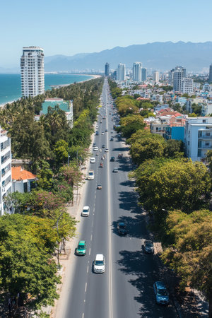 Scenic Coastal Cityscape, Lush Greenery, Modern Buildings, Traffic Along The Road, Summertimeの素材