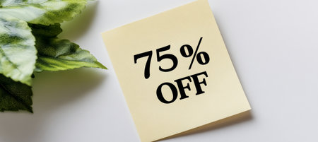 Yellow Square Sticky Note with 75 Off Text and Green Leaves Against White Backgroundの素材