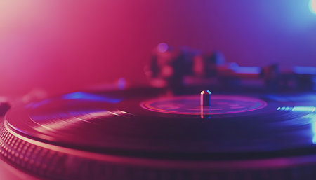 Spinning Vinyl Turntable with Colorful Glowing Backdrop, Capturing Musical Energy in Motion.の素材