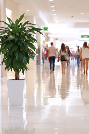 Bustling Shopping Mall with Shoppers in Motion Blur, Modern Retail Interior with Natural Elementの素材