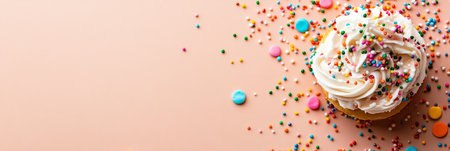 Festive Vanilla Cupcake Decorated with Colorful Sprinkles on a Pink Background, Birthday Celebrationの素材