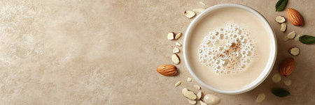 Top View Almond Milk in Bowl with Almonds and Leaves on Beige Background, Vegan Drinkの素材