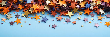 Vibrant Multicolored Paper Stars Scattered on a Light Blue Background, Festive Celebration Conceptの素材