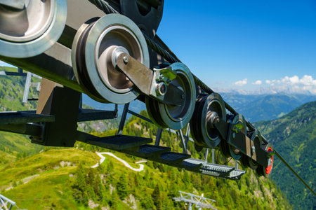Impressive Black Cable Car Wheel Overlooking Lush Green Mountains and Scenic Landscape Viewsの写真素材