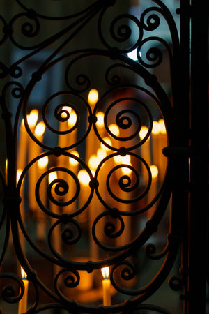 Exquisite ornate metal latticework with softly glowing candles beautifully arranged behind it