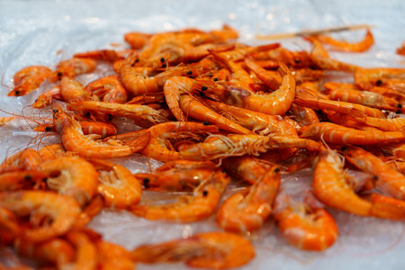 Freshly Cooked Tiger Prawns on Ice for Sale at a Bustling Local Seafood Market Experienceの写真素材