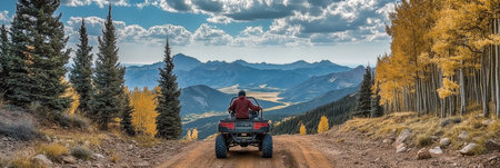 Man Exploring Autumn Forest Trails On All-Terrain Vehicle With Majestic Mountain Vistaの素材