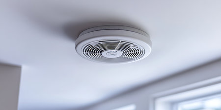 Modern Smoke Detector Mounted On White Ceiling With Clear Focus On Grill And Mounting Plateの素材