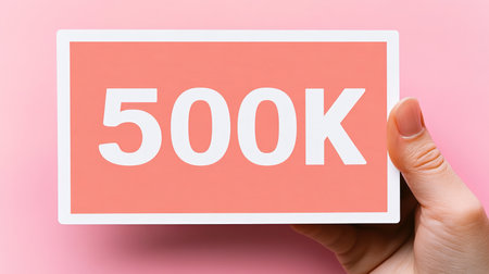 500K Celebration Hand Holding Achievement Banner, Success Concept on Pink Backgroundの素材