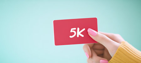 Woman Holding Red Card With 5K Text, Celebrating Social Media Milestone, Followers, Subscribersの素材