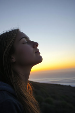Woman Finds Inner Peace, Serene Silhouette Against a Vibrant, Colorful Sunset Over the Oceanの素材