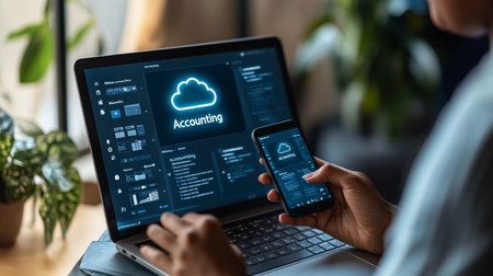 Businessman Using Cloud-Based Accounting Software, Managing Finances on Laptop and Mobile Device.の素材