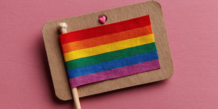 Rainbow Flag on Pink Background Symbol of LGBTQ Pride, Love, and Equality with Copy Spaceの素材