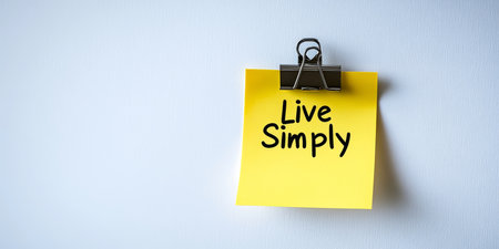 Close Up Of Yellow Sticky Note With Live Simply Message Hanging On White Wall, Minimalism Conceptの素材