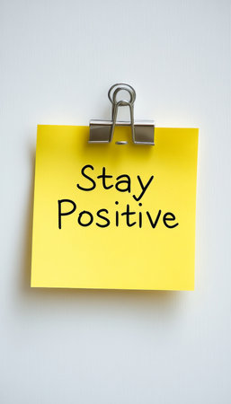 Stay Positive Yellow Sticky Note Reminder, Isolated on White Background With Copy Spaceの素材