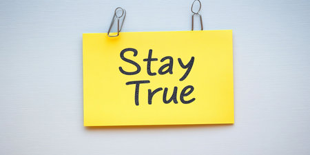 Yellow Sticky Note With The Text Stay True Attached With Paper Clips To A White Backgroundの素材