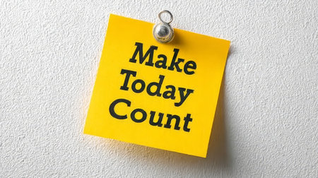 Yellow Sticky Note with Motivational Quote Make Today Count Pinned to White Backgroundの素材