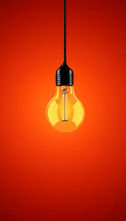 Vibrant Red Background with Illuminated Lightbulb, Perfect for Creative Ideas and Designsの素材