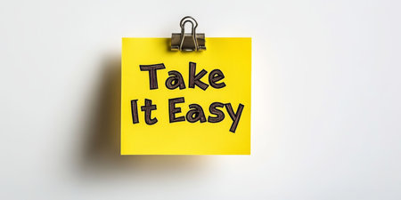 Isolated Yellow Sticky Note With Take It Easy Message Clipped to a White Backgroundの素材