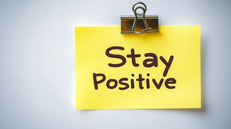 Yellow Sticky Note With Stay Positive Handwritten Text. Motivational Quote On White Background.の素材