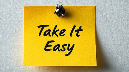 Yellow Sticky Note With The Words Take It Easy On White Background, Relaxation Conceptの素材