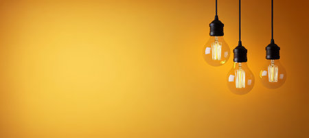 Vintage Style Light Bulbs with Filament Against a Warm Orange Wall, Perfect for Creative Decor Ideasの素材