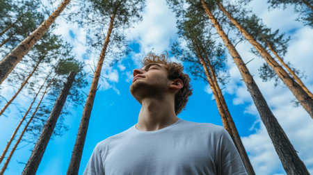 Young Man Enjoying Fresh Air, Finding Serenity and Nature Connection in a Majestic Pine Forestの素材