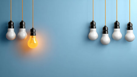 A Single Glowing Light Bulb Stands Out Amongst a Row of White Lights Against a Blue Backgroundの素材