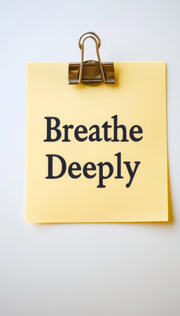 Mindfulness Reminder on Yellow Sticky Note with Breathe Deeply Message for Relaxation and Focusの素材