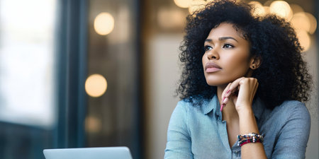 Deep Thoughtful Black Businesswoman Lost in Future Imagination with Laptop, Looking Sad in Officeの素材