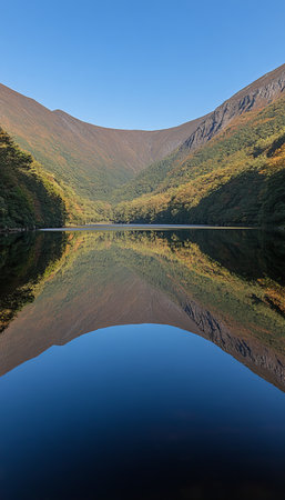 Autumn s Embrace Serene Lake Reflections Surrounded by Vibrant Mountains and Fall Colorsの素材