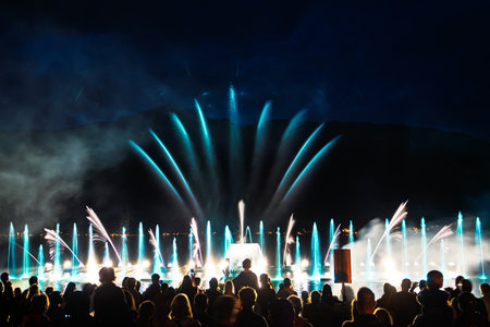 Spectacular Water Fountain Display with Lights and Crowd in the Night Sky Landscapeの写真素材