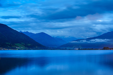 Tranquil Blue Hour Scene Serene Lake Reflecting Majestic Mountains and Cloudy Sky Vista