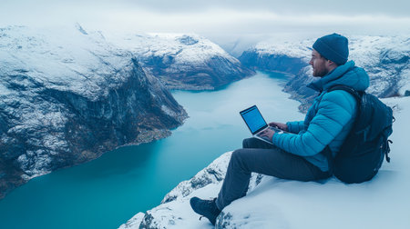Digital Nomad Working Remotely in Norway s Scenic Landscape with Snow-Covered Mountains and Fjordの素材