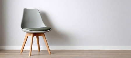 Stylish minimalist modern chair with wooden legs and padded seat in bright room with white wallsの素材