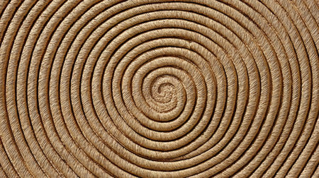 Intricately Designed Spiral of Tan Woven Straw Creating Symmetrical Rings for Elegant Decorationの素材