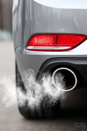 Modern Car Rear View Emitting Exhaust Gases, Highlighting Vehicle Pollution and Environmental Impactの素材