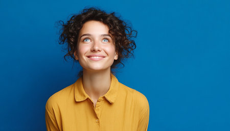 Optimistic Young Woman with a Radiant Smile Gazing Upward, Exuding Enthusiasm and Positive Energyの素材